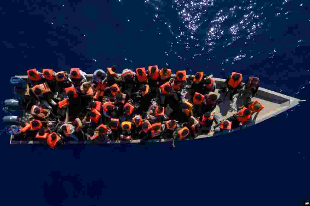 Migrants from Eritrea, Libya and Sudan sail a wooden boat before being assisted by aid workers of the Spanish NGO Open Arms, in the Mediterranean sea, about 30 miles north of Libya, June 17, 2023. 