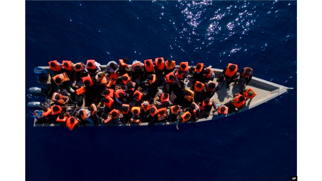 Migranti iz Eritreje, Libije i Sudana plove drvenim čamcem prije nego štosi im pomogli humanitarni radnici španske nevladine organizacije Open Arms, u Sredozemnom moru, oko 30 milja sjeverno od Libije, 17. juna 2023.