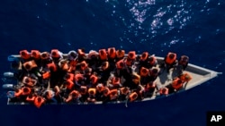 FILE - Migrants from Africa sail a wooden boat in the Mediterranean Sea, about 30 miles north of Libya, June 17, 2023. At least 49 migrants from Somalia died when their boat capsized June 10, 2024, off the coast of Yemen, according to the International Organization for Migration.