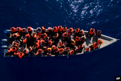 Migrants from Eritrea, Libya and Sudan sail a wooden boat before being assisted by aid workers of the Spanish NGO Open Arms, in the Mediterranean sea, about 30 miles north of Libya, June 17, 2023.
