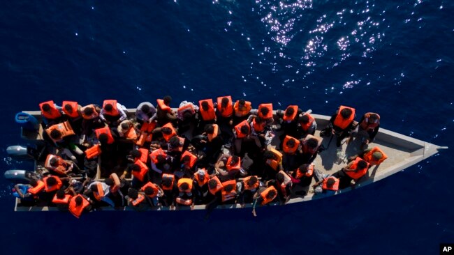 FILE - Migrants from Eritrea, Libya and Sudan sail a wooden boat before being assisted by aid workers of the Spanish NGO Open Arms, in the Mediterranean sea, about 30 miles north of Libya, June 17, 2023. 