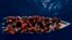 FILE - Migrants from Africa sail a wooden boat in the Mediterranean Sea, about 30 miles north of Libya, June 17, 2023. At least 49 migrants from Somalia died when their boat capsized June 10, 2024, off the coast of Yemen, according to the International Organization for Migration.