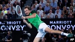 Daniil Medvedev of Russia plays a backhand return to Jannik Sinner of Italy during the men's singles final at the Australian Open tennis championships at Melbourne Park, in Melbourne, Jan. 28, 2024.