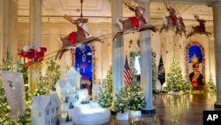 Holiday decorations adorn the Grand Foyer of the White House for the 2023 theme "Magic, Wonder, and Joy," Monday, Nov. 27, 2023, in Washington. (AP Photo/Evan Vucci)