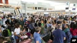 Para penumpang penerbangan international memenuhi terminal di Bandara Haneda menjelang badai kuat yang mendekati Tokyo, Jumat, 16 Agustus 2024. (Foto: Kyodo News via AP)