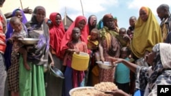 FILE — Somalis, displaced by a drought, receive food at a camp on the outskirts of Mogadishu, Somalia, March 30, 2017.