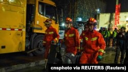 中国齐齐哈尔消防员手持救援工具参加在齐齐哈尔中学体育馆房顶塌陷后的搜救行动。（2023年7月24日）