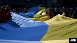 Members of the Ukrainian diaspora unfurl a 100-metre Ukrainian flag to mark the Independence Day of Ukraine in Katowice, Silesian region, on Aug. 24, 2024. 