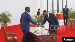 Rais William Ruto akipeana mkono na waziri mpya kutoka upinzani Hasan Ali Joho wakati wa kuapishwa kwa baraza lake jimpya la mawaziri huko Nairobi Agosti 8, 2024 Picha na Reuters 