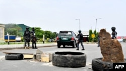 FILE - Police officers stand at a barricade on Lagos expressway as they enforce a restriction imposed on movement of motorists during local elections, in Lagos, on March 18, 2023.