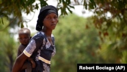 Twenty-eight-year-old Milla Nemoudji, a woman who was divorced by her husband following years of physical abuse, is photographed in a village of Binmar, Chad, Friday, July 19, 2024. (AP Photo/Robert Bociaga)
