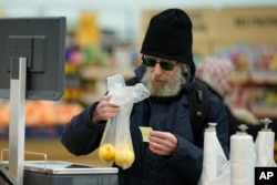 Pembeli buah-buahan di sebuah hipermarket di Moskow, Rusia, 3 November 2023. terlihat kecewa mengamati harga yang melonjak karena inflasi. (AP)