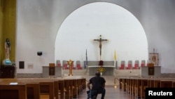 ARCHIVO: Un hombre se arrodilla en la Catedral Metropolitana de la Inmaculada Concepción de María cuando la policía nicaragüense prohibió una procesión y peregrinación católica en la capital, citando razones de seguridad interna, en Managua, Nicaragua, el 12 de agosto de 2022.