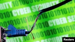 FILE - Broken Ethernet cable hangs in front of binary code and words "CYBER SECURITY" in an illustration photographed on March 8, 2022. Several U.S. agencies warned Wednesday that China-linked hackers had infiltrated some U.S. companies linked to sectors such as energy and water.