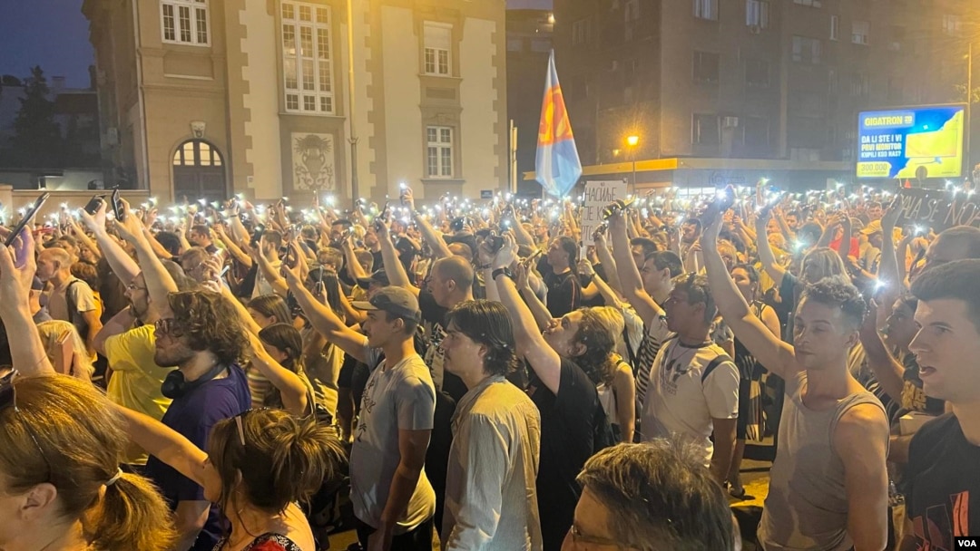 ARHIVA - Građani drže telefone sa upaljenim svetlima ispred sedišta beogradske policije, 8. jula 2023. (Foto: VOA/Rade Ranković)