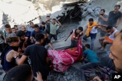 Warga Palestina membawa jenazah dari bawah reruntuhan rumah yang hancur pasca serangan udara Israel di Kota Gaza, 4 November 2023. (Foto: AP)