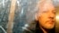 FILE - Buildings are reflected in the window as WikiLeaks founder Julian Assange is taken from court, where he appeared on charges of jumping British bail, in London, May 1, 2019.