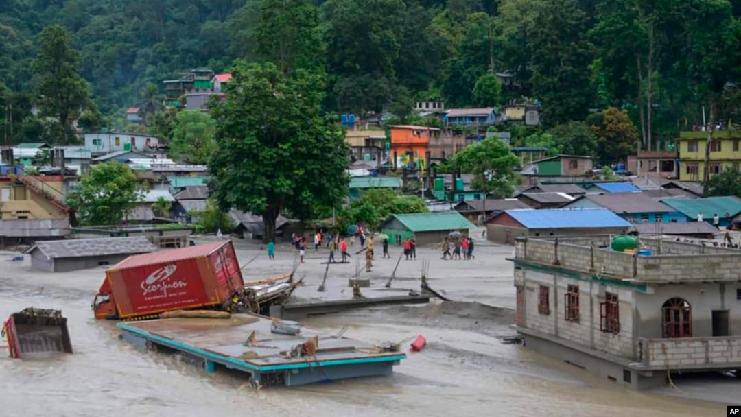 A vehicle that got washed away lies atop a submerged building after flash floods triggered by a sudden heavy rainfall swamped the Rangpo town in Sikkim, India, Oct.5. 2023. 