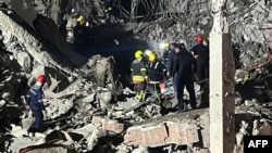 This handout photo, taken and released Jan. 16, 2024, by broadcast news station Kurdistan 24, shows firemen and security staff at the site of impact of a missile launched by Iran, in Irbil, the capital of Iraq's northern autonomous Kurdish region.