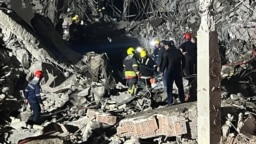 This handout photo, taken and released Jan. 16, 2024, by broadcast news station Kurdistan 24, shows firemen and security staff at the site of impact of a missile launched by Iran, in Irbil, the capital of Iraq's northern autonomous Kurdish region.