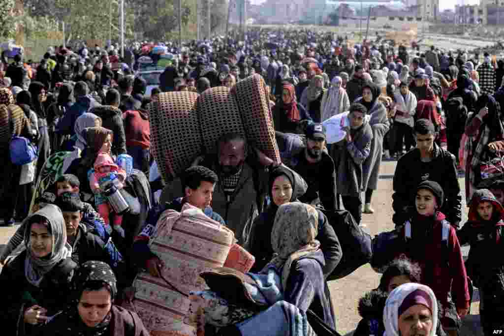 Palestinians carry some belongings as they flee Khan Younis to safer areas farther south in the southern Gaza Strip through the city's western exit on the outskirts of its refugee camp.