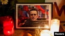 资料照片：2024年2月19日，俄罗斯反对派领导人阿列克谢·纳瓦尔尼去世后，人们在法国巴黎埃菲尔铁塔附近的特罗卡德罗参加守夜活动时点燃的蜡烛。（路透社照片）