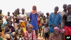 FILE- Internally displaced people wait for aid in Djibo, Burkina Faso, May 26, 2022. 