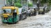 Para penumpang kendaraan harus berjuang melintasi jalan yang tergenang banjir setelah hujan lebat di kota Amritsar, negara bagian Punjab, India. (AFP)&nbsp;