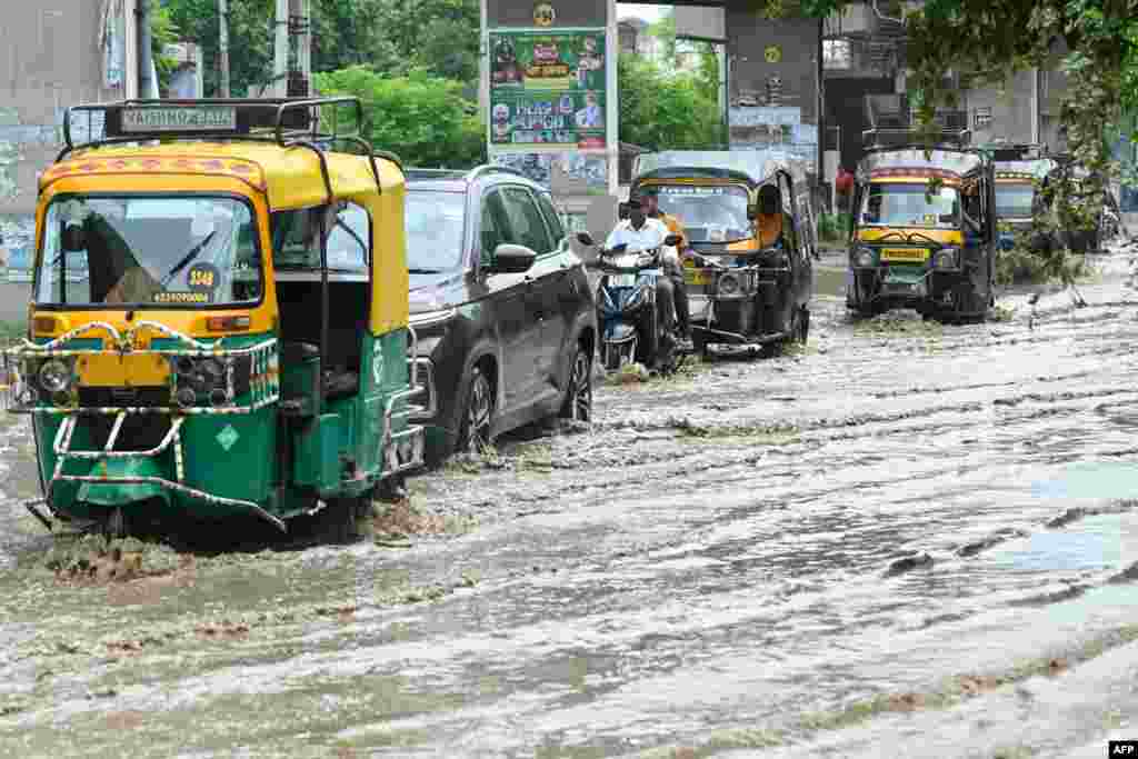 Commuters wade through a street after heavy rainfall in Amritsar.