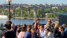 Sejumlah orang tampak menikmati minuman dan snacks di Stockholm, pada 30 Mei 2023. (Foto: AP/Karl Ritter)