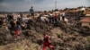 Para petugas dari tim Palang Merah Uganda berlalri untuk meminta bantuan dalam upaya pencarian korban longsoran sampah di Kampala, Uganda, pada 10 Agustus 2024. (Foto: AFP/Badru Katumba)