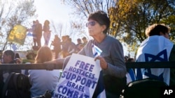 A woman holds a sign saying "Free Hostages, Support Israel, Combat Antisemitism" while attending a march to support Israel on the National Mall in Washington, Nov. 14, 2023.
