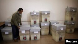 ঢাকায় সংসদ নির্বাচনের আগে একটি বিতরণ কেন্দ্রে ব্যালট বাক্স বাছাই করছেন নির্বাচন কমিশনের একজন সদস্য। (ফাইল ছবি) 