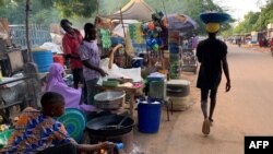 FILE - A man walks past a street side market in Niamey, Sept. 20, 2023. A lawsuit filed by Niger's transitional leaders over sanctions on Niger was dismissed on Dec. 7, 2023. Since the sanctions were imposed following the July coup, millions of citizens have struggled to get by. 