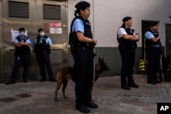 Police officers patrol outside a polling station during the District Council elections in Hong Kong, Dec. 10, 2023.