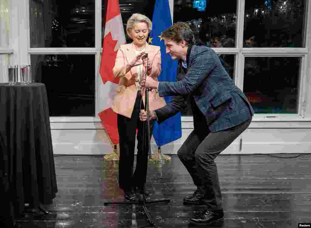 Canadian Prime Minister Justin Trudeau adjusts the microphone for European Commission President Ursula Von Der Leyen as she speaks at the opening reception of the 19th EU-Canada summit in St John's, Newfoundland.