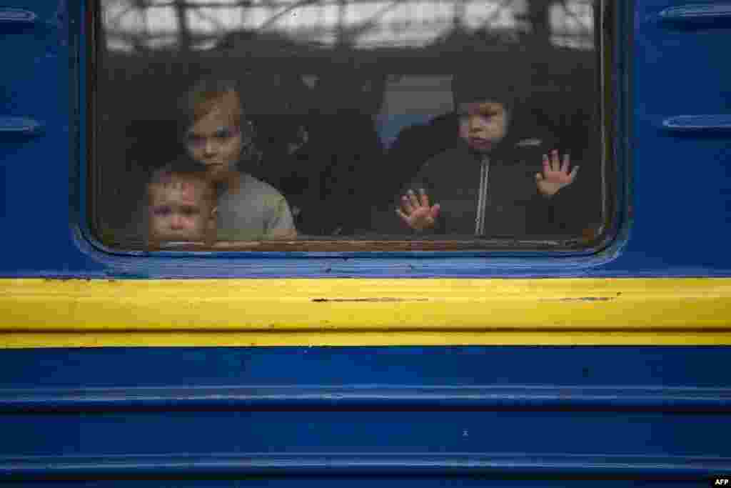 Дети смотрят из окна поезда, отправляющегося из Львова в Ужгород на границе со Словакией. 3 марта 2022. &nbsp;
