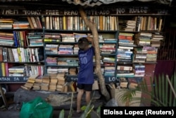 A boy picks out a book at Hernando Guanlao's home library in Makati, a metro area of Manila, Philippines, Feb. 7, 2024. (REUTERS/Eloisa Lopez)