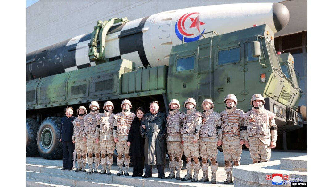 Pemimpin Korea Utara Kim Jong Un dan putrinya menghadiri sesi foto bersama para ilmuwan, insinyur, pejabat militer, dan pihak lain yang terlibat dalam uji coba rudal balistik antarbenua (ICBM) Hwasong-17 yang baru pada 2022. (Foto: KCNA via REUTERS)