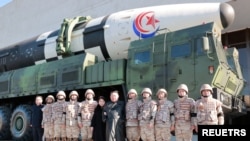 FILE - North Korean leader Kim Jong Un and his daughter attend a photo session with the scientists, engineers, military officials and others involved in the test-fire of the country's new Hwasong-17 intercontinental ballistic missile (ICBM).