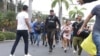 La policía evacua al personal de la estación de televisión pública TC después de que un grupo de hombres armados irrumpiera en su set durante una transmisión en vivo, en Guayaquil, Ecuador, el martes 9 de enero de 2024.