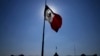 FILE - A Mexican flag waves in Mexico City's main square at sunrise, April 24, 2023. Mexican authorities said a bus crashed in Mexico on Friday, killing 24 and injuring five.