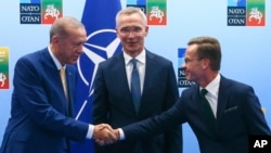 FILE - Turkey's President Recep Tayyip Erdogan, left, shakes hands with Swedish Prime Minister Ulf Kristersson, right, as NATO Secretary General Jens Stoltenberg looks on prior to a meeting ahead of a NATO summit in Vilnius, Lithuania, July 10, 2023.
