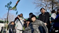 The Twin Cities Hmong community gather for a Hmong New Year sweeping ritual in St. Paul, Minnesota, Nov. 18, 2023. The ritual, in which participants walk together in circles, represents leaving old negative spirits behind and embracing the new year.