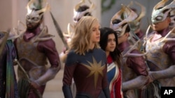 This image released by Disney shows Brie Larson, left, and Iman Vellani in a scene from "The Marvels." (Laura Radford/Disney-Marvel Studios via AP)