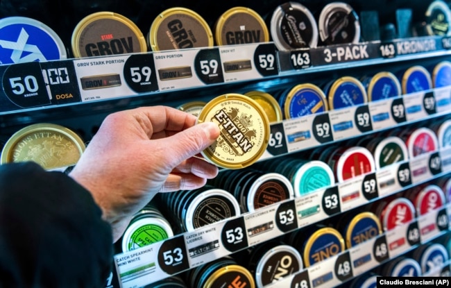 FILE - A man holds a box of snus (snuff), a smokeless tobacco product that’s illegal elsewhere in the European Union but is marketed in Sweden as an alternative to cigarettes. (Claudio Bresciani /TT News Agency via AP, File)