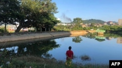 This photo taken Nov. 7, 2023, shows a man watching smoke rising from the direction of a Myanmar military base in Lashio township, northern Shan state. 