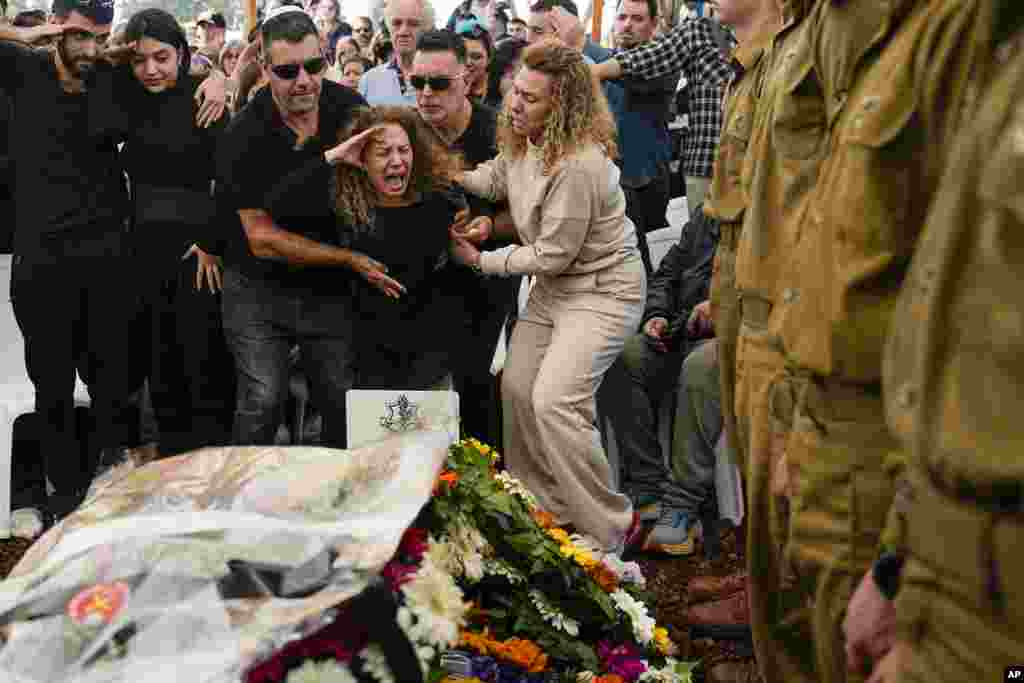 Sivan, mother of Israeli soldier Sergeant Dolev Malca, screams as she salutes her son during his funeral in Shlomi, northern Israel, on the border with Lebanon.