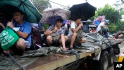 Residents ride a truck as they negotiate a flooded street caused by heavy rains from Tropical Storm Yagi, locally called Enteng, in Cainta, Rizal province, Philippines, Sept. 2, 2024.