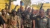 FILE — This picture released on the Sudanese Army’s Facebook page on May 30, 2023, shows army chief Abdel Fattah al-Burhan cheering with soldiers as he visits some of their positions in Khartoum. 